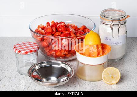 Les ingrédients pour faire de la confiture de fraises maison sont disposés sur une table avant la confiture Banque D'Images