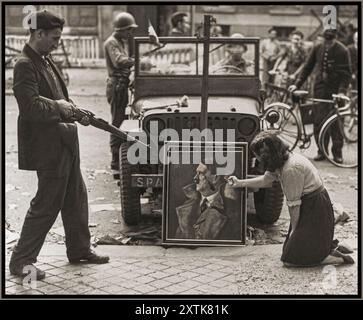 LA RÉSISTANCE FRANÇAISE DE LA seconde Guerre mondiale PARIS Un civil français et un combattant de la résistance française dégradent un portrait nazi officiel d'Adolf Hitler. Août 1944 Paris, [Seine] France Banque D'Images