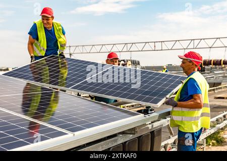 Neuendorf, Allemagne. 15 août 2024. Les travailleurs de Pfalzsolar installent des modules solaires pour le système photovoltaïque flottant sur la mer Baltique de Cottbus. Une fois terminé, il couvrira 18 hectares du lac (environ un pour cent) avec 51 000 modules solaires. En moyenne, le système peut générer 290000 mégawattheures d'énergie par an. Les corps flottants avec les modules solaires attachés à eux sont reliés au lit du lac par 34 points d'ancrage de sorte que les fluctuations des niveaux d'eau peuvent être compensées. Crédit : Frank Hammerschmidt/dpa/Alamy Live News Banque D'Images