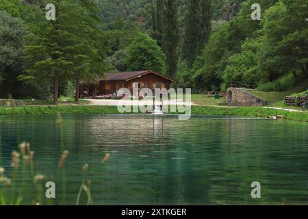 Une cabane en bois près d'un étang sur une journée fraîche d'été. Banque D'Images