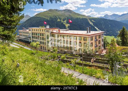 La Schatzalp au-dessus de Davos, Grisons, montre son côté arrière avec un pont face à la montagne qui servait d'entrée de service pour le personnel et les livraisons. Otto Pfleghard et Max Haefeli l'ont construite entre 1898 et 1900 pour Willem Jan Holsboer. Deux drapeaux suisses flottent sur le toit de l'hôtel actuel sur le sentier Thomas Mann, en Suisse. Banque D'Images