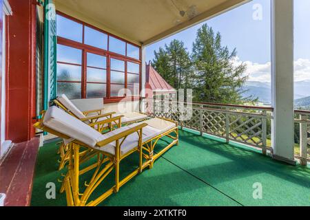 La Schatzalp au-dessus de Davos, Grisons, montre un balcon avec vue sur la vallée dans la salle appelée Impériale, où deux chaises longues en rotin avec des coussins blancs sont posées. L'empereur allemand Guillaume II avait loué cette salle de manière permanente, bien qu'il n'y ait jamais séjourné pour une cure. Otto Pfleghard et Max Haefeli ont construit l'ancien sanatorium entre 1898 et 1900 pour Willem Jan Holsboer. Une petite tourelle avec un toit pointu rouge s'élève au-dessus des épicéas à l'arrière-plan, Bobbahnstrasse, Suisse. Banque D'Images