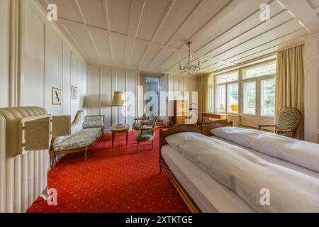 La Schatzalp au-dessus de Davos, Grisons, montre une suite lambrissée avec une chaise longue, un lustre et un tapis rouge dans le soi-disant Salon Impérial. L'empereur Guillaume II avait réservé en permanence trois chambres à la Schatzalp – les actuelles chambres 101, 201 et 301 – au cas où un membre de la famille tomberait malade et aurait besoin d'un traitement pour la tuberculose. Aucun membre de la famille Hohenzollern n'y a jamais séjourné pour une cure, mais les chambres ont conservé le nom de « Kaiserzimmer » (Salon Impérial) jusqu'à aujourd'hui. Otto Pfleghard et Max Haefeli ont construit l'ancien sanatorium entre 1898 et 1900 pour Willem Jan Holsboer, Bobbahnstras Banque D'Images