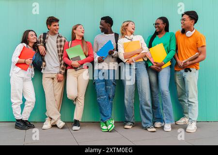 Un grand rassemblement d'étudiants adolescents, leurs rires résonnent à travers le campus universitaire alors qu'ils s'engagent dans des conversations animées. Des camarades de classe partageant des histoires et discutant avec animation après les cours. Photo de haute qualité Banque D'Images