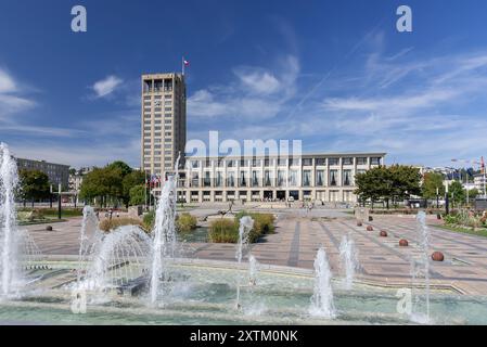 Le Havre - Hôtel de ville de la ville du Havre conçu par Auguste Perret après sa destruction lors de la seconde Guerre mondiale avec des jets d'eau au premier plan. Banque D'Images