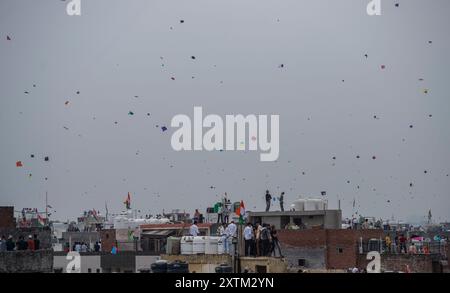 New Delhi, Inde. 15 août 2024. Les gens font voler des cerfs-volants depuis les toits de bâtiments à New Delhi, en Inde, le 15 août 2024. Crédit : Javed Dar/Xinhua/Alamy Live News Banque D'Images