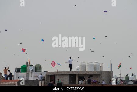 New Delhi, Inde. 15 août 2024. Les gens font voler des cerfs-volants depuis le toit d'un bâtiment à New Delhi, en Inde, le 15 août 2024. Crédit : Javed Dar/Xinhua/Alamy Live News Banque D'Images