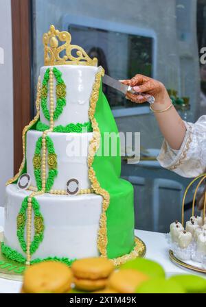 Gâteau de mariage à trois niveaux, vert et blanc, avec une couronne sur le dessus, avec le thème du caftan marocain Banque D'Images