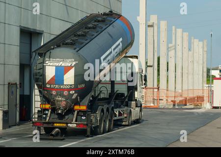 Rovato, Italie - 8 juin 2023 : un gros camion-citerne stationné, déchargeant sa cargaison dans une installation logistique contemporaine sous un ciel lumineux. Banque D'Images