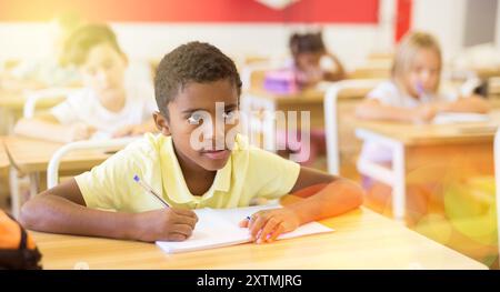 Jeune garçon afro-américain assidu étudiant en classe Banque D'Images