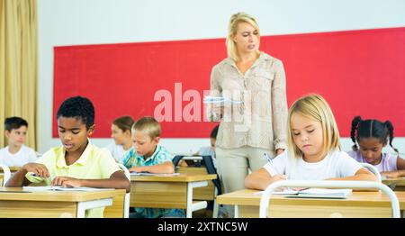 Élèves préadolescents ciblés étudiant en classe avec une enseignante Banque D'Images