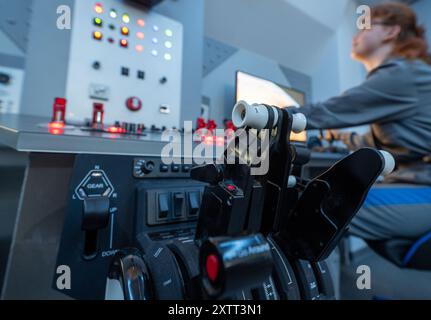 FILED - 15 août 2024, Saxe, Chemnitz : dans le cockpit de la nouvelle capsule spatiale du Centre cosmonaute Sigmund Jähn à Chemnitz, Zoe Klose guide à travers l'immensité de l'espace. Après une rénovation complète, la capsule spatiale décollera à nouveau à l'occasion du 60e anniversaire de l'installation avec des vols spatiaux simulés pour les passagers de tous âges. Samedi (17.08.2024), le Solaris Development Center, sponsor du Cosmonaut Center, organise une célébration d’anniversaire. L'installation pour enfants et jeunes est dédiée aux voyages spatiaux depuis 1964 et apporte l'immensité beyo Banque D'Images