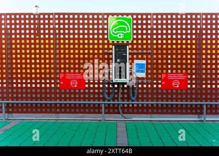 Tarragone, Espagne - 15 juillet 2024 : borne de recharge moderne pour véhicules électriques avec signalisation claire pour le stationnement et l'utilisation. Banque D'Images