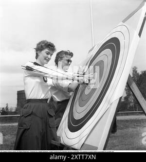 Tir à l'arc 1957. Deux femmes du tir à l'arc de Stockholm à la cible avec les flèches presque au milieu. L'un d'eux note le score sur un protocole. Kristoffersson Réf. BY46-12 Banque D'Images