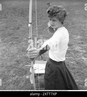 Tir à l'arc 1957. Une femme du club de tir à l'arc de Stockholm avec son arc. Elle montre comment tenir le corps et les bras dans la bonne position pour tirer. Elle porte un couvre-poignet pour se protéger. Elle a également un porte-flèche en cuir spécial dans sa main. Kristoffersson Réf. BY46-12 Banque D'Images