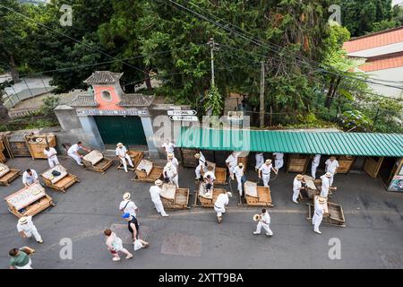 Les ouvriers sur les toboggans touristiques en osier Camacha attendent les clients qui veulent descendre à Funchal, Madère vu le 31 juillet 2024. Banque D'Images