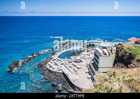 Regardant vers le bas les gens profitant des piscines naturelles de roche à Porto Moniz au nord de Madère, Portugal photographié le 1er août 2024. Banque D'Images