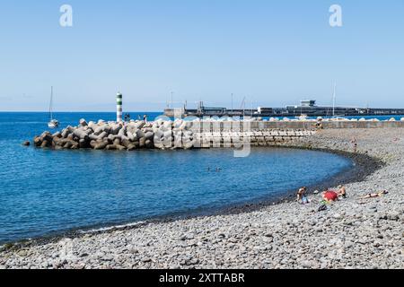 Les gens apprécient et prennent le soleil dans une petite baie artificielle à Funchal, Madère, le 6 août 2024 Banque D'Images