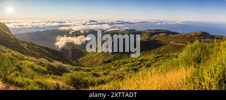 Un panorama multi-image du soleil se levant sur l'océan Atlantique et des nuages autour de l'île de Madère vu depuis Pico do Areeiro. Banque D'Images