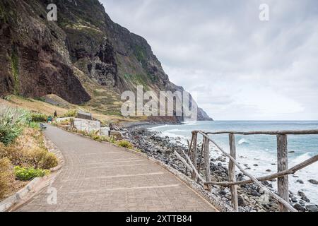 Regardant le long d'un sentier sinueux au pied des falaises de mer à Achadas da Cruz sur la côte ouest de l'île de Madère. Banque D'Images