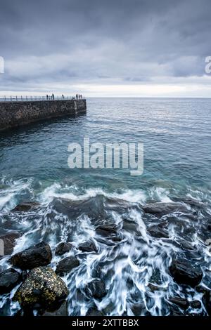 Les gens ont photographié le coucher du soleil depuis une vieille jetée dans un entrepôt de charbon, mais Funchal, Madère, le 11 août 2024. Banque D'Images