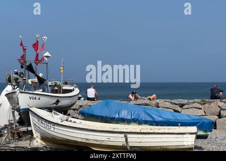 16.08.2024 Touristen sitzen und liegen auf einer Mauer am Strand in Vitt, einem Fischerdorf auf der vorpommerschen Insel Rügen im Landkreis Vorpommern-Rügen in Mecklenburg-Vorpommern. DAS Dorf gehört zur Gemeinde Putgarten. DAS unter Denkmalschutz stehende dorf ist sehr gut erhalten und erfreut sich eines stetigen Besucherstroms. KAP Arkona Ostsee Mecklenburg-Vorpommern Deutschland *** 16 08 2024 touristes assis et allongé sur un mur sur la plage de Vitt, un village de pêcheurs sur l'île de Rügen dans le district de Vorpommern Rügen dans le Mecklenburg-Vorpommern le village appartient à la municipalité de P. Banque D'Images