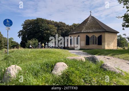 16.08.2024 Besucher auf dem Weg zur Kapelle von Vitt, oberhalb des gleichnamigen Fischerdorfes Vitt, einem Fischerdorf auf der vorpommerschen Insel Rügen im Landkreis Vorpommern-Rügen in Mecklenburg-Vorpommern. Die Kapelle ist ein einfacher oktogonaler Bau mit Reetdach. DAS Dorf gehört zur Gemeinde Putgarten und steht unter Denkmalschutz. KAP Arkona Ostsee Mecklenburg-Vorpommern Deutschland *** 16 08 2024 visiteurs sur le chemin de la chapelle de Vitt, au-dessus du village de pêcheurs du même nom Vitt, un village de pêcheurs sur l'île de Rügen dans le district de Vorpommern Rügen en Mecklembourg-Vorpomm Banque D'Images