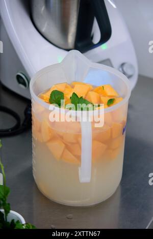 Cantaloup fraîchement coupé en cours de préparation pour une boisson rafraîchissante d'été Banque D'Images