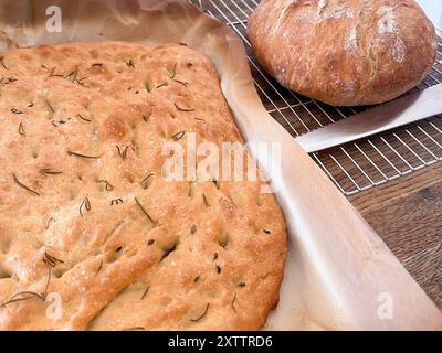 Focaccia fraîchement cuit et pain rond refroidissement sur une grille métallique Banque D'Images