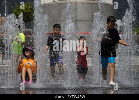 Séoul, Corée du Sud. 16 août 2024. Les enfants jouent dans la fontaine au milieu d'une canicule à Séoul, Corée du Sud, le 16 août 2024. Crédit : Jun Hyosang/Xinhua/Alamy Live News Banque D'Images