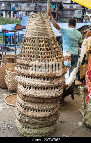 Articles ménagers en osier au bazar Haat à Khandbari, district de Sankhuwasabha. Népal. Le panier conique est doko et les plateaux circulaires sont Nanglo. Banque D'Images