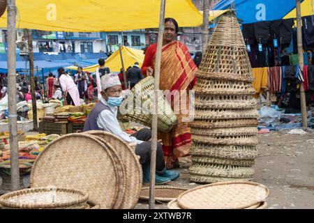 Articles ménagers en osier au bazar Haat à Khandbari, district de Sankhuwasabha. Népal. Le panier conique est doko et les plateaux circulaires sont Nanglo. Banque D'Images