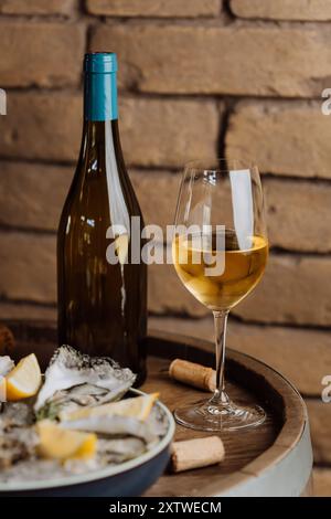 Huîtres élégantes sur glace avec citron et vin, parfaites pour les repas gastronomiques et les occasions spéciales Banque D'Images