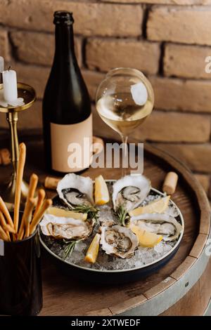 Huîtres fraîches sur glace avec citron et vin, parfaites pour des expériences culinaires de luxe et des célébrations Banque D'Images