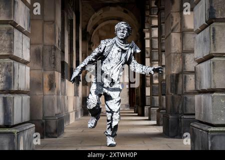 L'artiste Estevan Mortensen, originaire de l'Équateur, se produit en tant que « statue vivante » sur le Royal Mile tout au long du Festival Fringe d'Édimbourg. Son personnage de « pochoir humain » est inspiré par le Street-artiste Banksy. Date de la photo : vendredi 16 août 2024. Banque D'Images