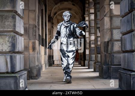 L'artiste Estevan Mortensen, originaire de l'Équateur, se produit en tant que « statue vivante » sur le Royal Mile tout au long du Festival Fringe d'Édimbourg. Son personnage de « pochoir humain » est inspiré par le Street-artiste Banksy. Date de la photo : vendredi 16 août 2024. Banque D'Images