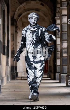 L'artiste Estevan Mortensen, originaire de l'Équateur, se produit en tant que « statue vivante » sur le Royal Mile tout au long du Festival Fringe d'Édimbourg. Son personnage de « pochoir humain » est inspiré par le Street-artiste Banksy. Date de la photo : vendredi 16 août 2024. Banque D'Images