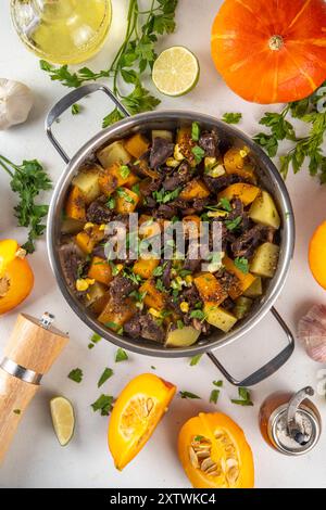 Ragoût de citrouille chaud avec de la viande de pomme de terre et de boeuf, repas d'automne réconfortant, nourriture équilibrée, avec des ingrédients sur la table de cuisine Banque D'Images