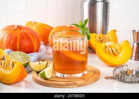 Margarita de Thanksgiving, cocktail d'arbustes de citrouille douce, boisson d'automne savoureuse à l'alcool sur fond blanc avec des tranches de citrouilles, espace de copie Banque D'Images