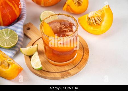 Margarita de Thanksgiving, cocktail d'arbustes de citrouille douce, boisson d'automne savoureuse à l'alcool sur fond blanc avec des tranches de citrouilles, espace de copie Banque D'Images