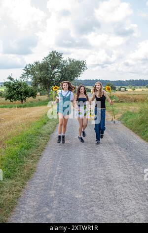 Des jeunes filles tenant des tournesols Banque D'Images