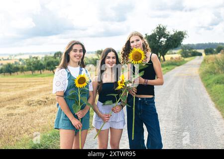 Des jeunes filles tenant des tournesols Banque D'Images