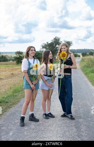 Des jeunes filles tenant des tournesols Banque D'Images