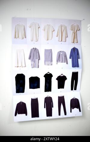 Assortiment de vêtements pour hommes affichés sur un mur blanc, y compris des chemises, des pantalons et une veste. Banque D'Images