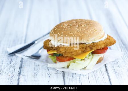 Fish Burger (mise au point sélective, gros plan) sur fond de bois Banque D'Images