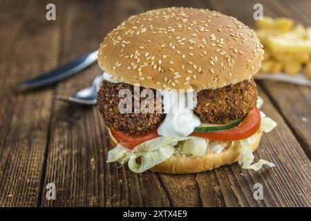 Falafel Burger végétarien sur une vieille table en bois (gros plan, mise au point sélective) Banque D'Images