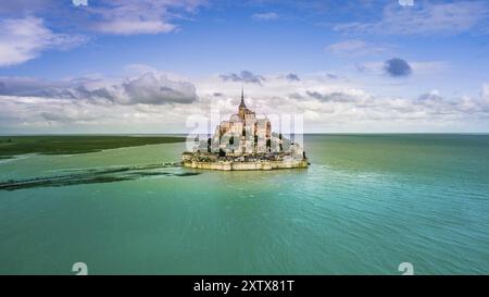 Le Mont Saint-Michel tidal island avec de l'eau d'un bleu profond dans la lumière du soir d'or Banque D'Images