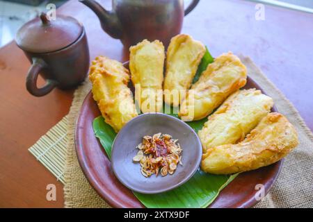 bananes frites ou pisang goreng servies dans une assiette avec feuille de banane. L'assiette est sur une table en bois Banque D'Images