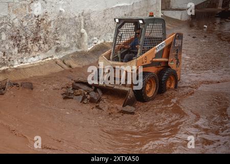 Es Mercadal, Espagne. 16 août 2024. Les résidents, les services d'urgence et les équipages routiers tentent de rétablir l'ordre et de réparer les dégâts causés par les fortes pluies et les tempêtes de la DANA (un système isolé de basse pression à niveaux élevés). La zone du centre de Minorque cherche à être déclarée zone catastrophe afin d'obtenir une aide gouvernementale. Crédit : Matthias Oesterle/Alamy Live News Banque D'Images