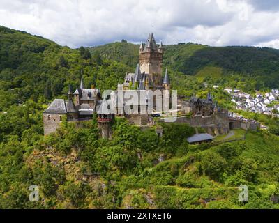 Un impressionnant château médiéval sur une colline verdoyante avec une végétation dense et des nuages dans le ciel, vue aérienne, Reichsburg, Cochem, Cochem-Zell, Moselle, Rhin Banque D'Images